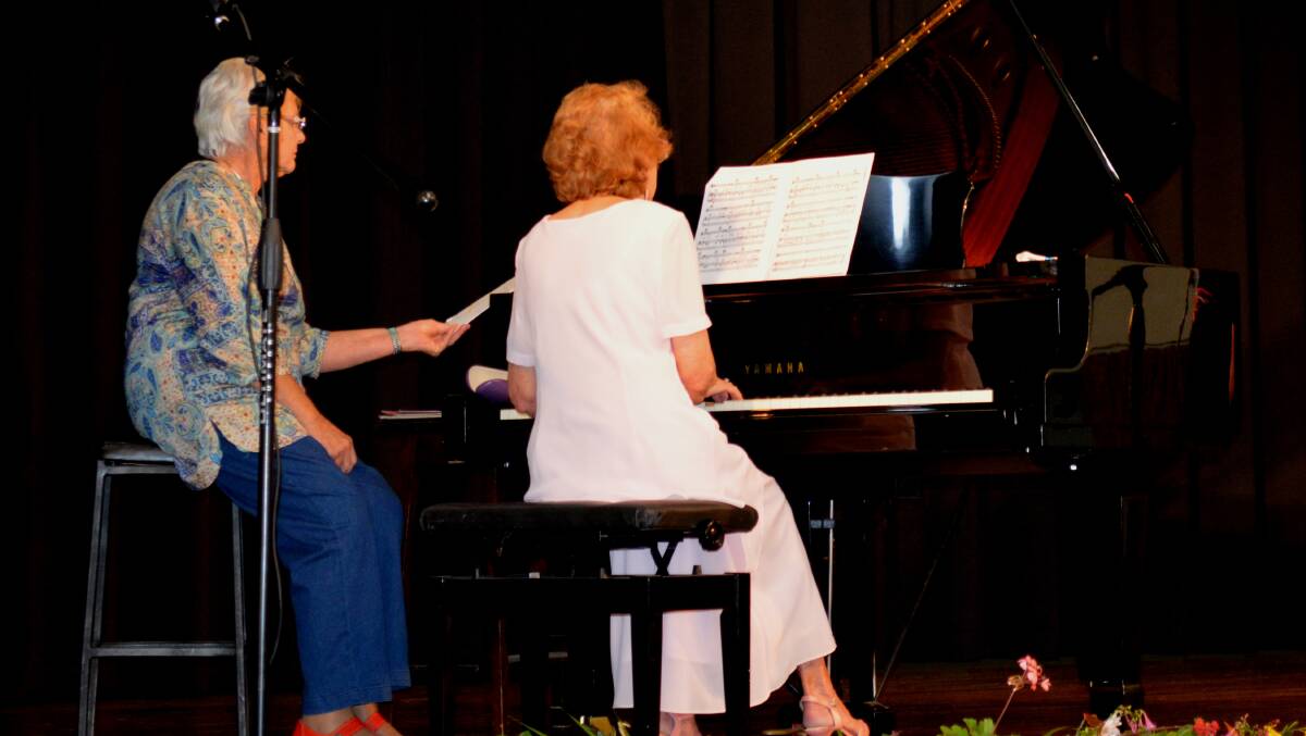 Phyllis Rea Lloyd performing on piano at this event with Lynette Lyneham assisting