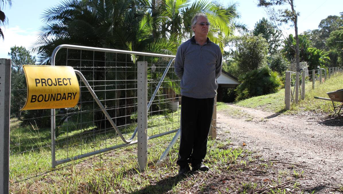 GUTTED: Paul stands on the highway upgrade project boundary - which is also the fence-line of his, and his neighbours, Old Coast Rd properties