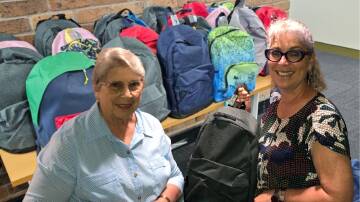 Walcha Rotary Club member, Lois with Maria Showell of Pathfinders with the backpacks donated for children in foster care. Picture supplied. 