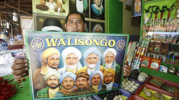 A vendor of merchandise at the shrine with a poster of the Wali Songo, or nine saints, credited with bringing Islam to Java. Photo: Irwin Fedriansyah