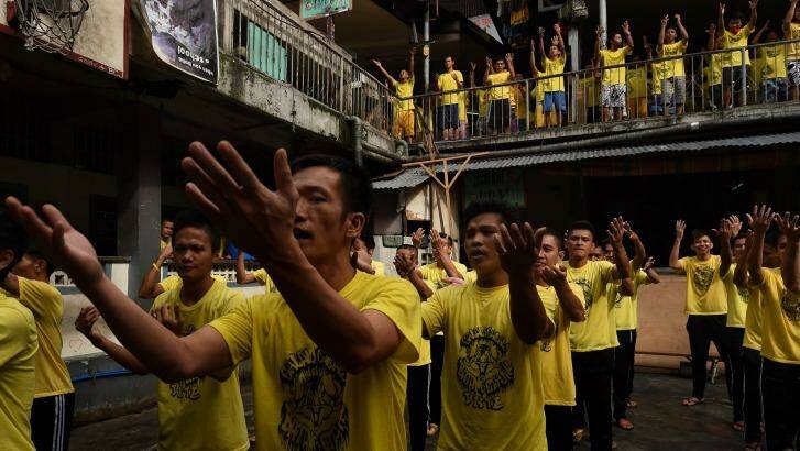 Prisoners sing and dance during an exercise routine inside Quezon city jail, Philippines. . Photo: Kate Geraghty