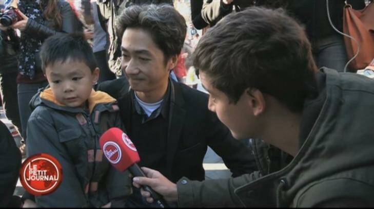 Brandon, and his father, Angel Le, are interviewed by a reporter for French TV show <em>Le Petit Journal</em>. Photo: Le Petit Journal