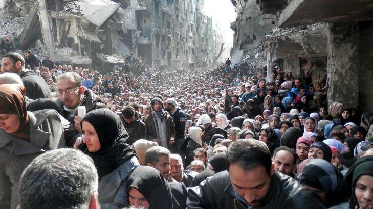 Residents of Yarmouk queuing for food in January 2014. Once home to 145,000 Palestinian refugees, the town has been taken over by Islamic State militants, forcing most residents and aid workers to leave and isolating those left behind. Photo: UNRWA