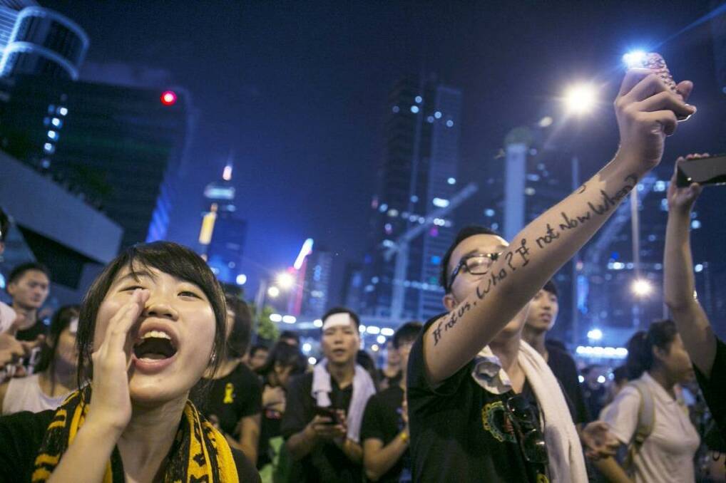  Student protesters chant pro-democracy slogans and shine their mobile phones during evening speeches at the protest site in Hong Kong. Photo: Paula Bronstein/Getty Images