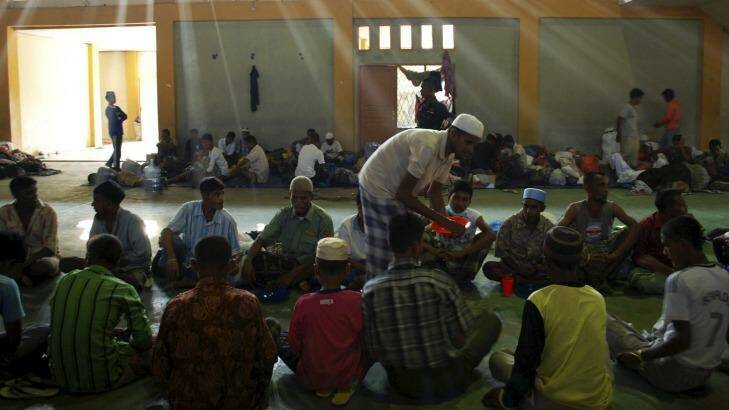 Rohingya and Bangladeshi migrants receive food inside a temporary shelter in Lhoksukon in Aceh. Photo: Antara Foto/Reuters