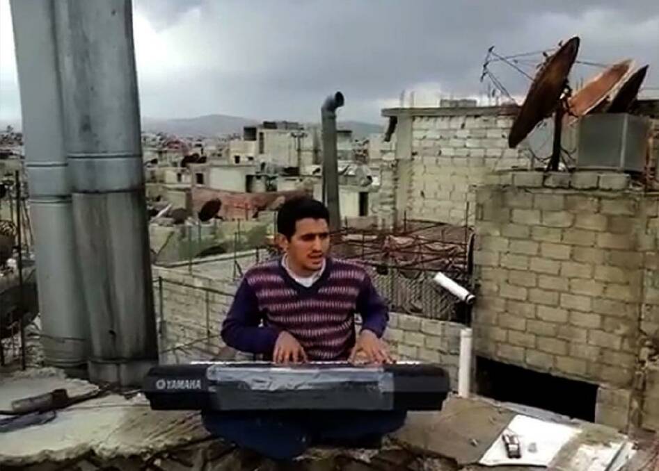 Ayham al-Ahmad rehearses a song on a rooftop in Yarmouk refugee camp. Photo: Supplied
