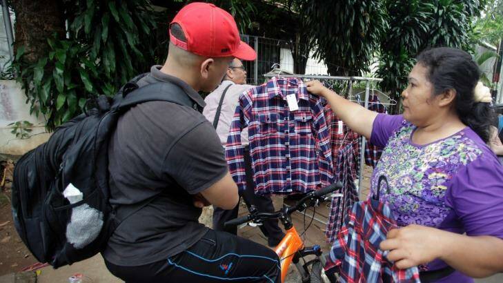 Santi Panggabean, right, does a brisk trade in Ahok's trademark plaid shirt. But the governor's popularity is not reflected in election polling. Photo: Irwin Fedriansyah