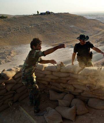 Vantage point: Peshmerga fighters pile up sandbags to make a gun placement on the road to Makhmur. Photo: Ahmed Jadallah