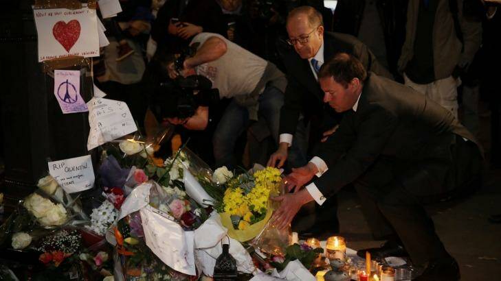 Australia's Energy Minister Josh Frydenberg, right, and Ambassador Stephen Brady place flowers at the Bataclan memorial in Paris on Monday. Photo: Andrew Meares