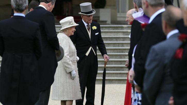The Queen and Prince Philip greet guests on the grounds of Buckingham Palace on Thursday. Photo: Jonathan Brady 