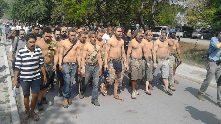 Students in Papua New Guinea march to campus with mud on their bodies as a symbol of mourning after police last week shot protesters at the university. Photo: Supplied