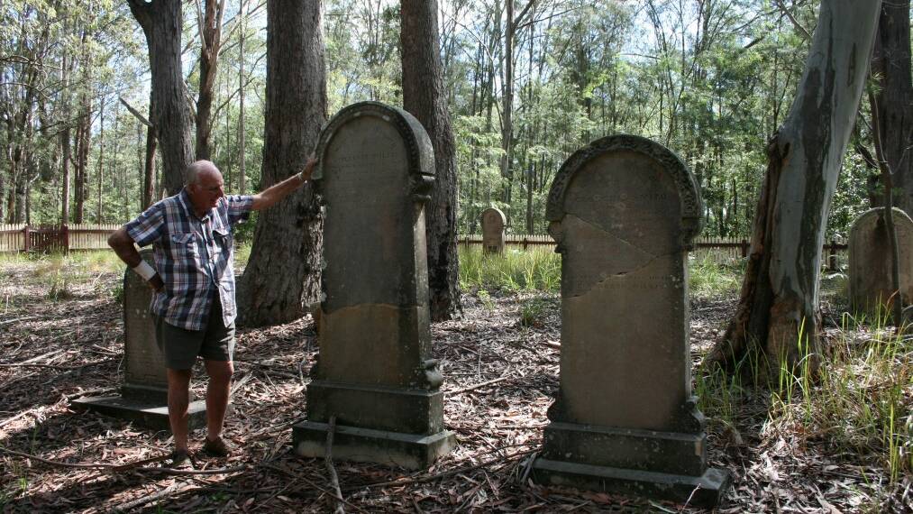 TOUCHING HISTORY: Clyde Piggott reading a headstone in Blackbutt Cemetery. The headstone of his great grandparents is in the background