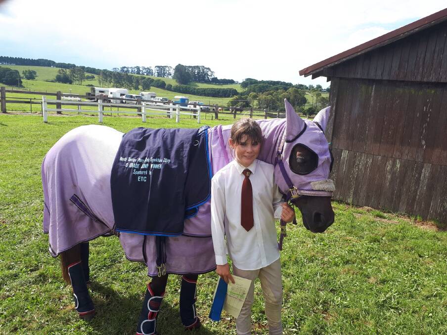 Jorja Woods and her mount Bailee wearing the commemorative D Grade Two
Phase Showjumping rug