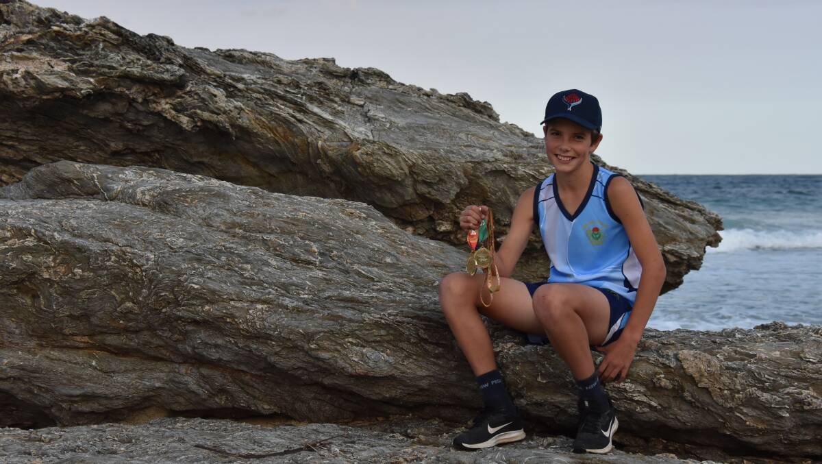 Daniel Williams with his medal harvest at Main Beach, Nambucca Heads. Photo: Christian Knight