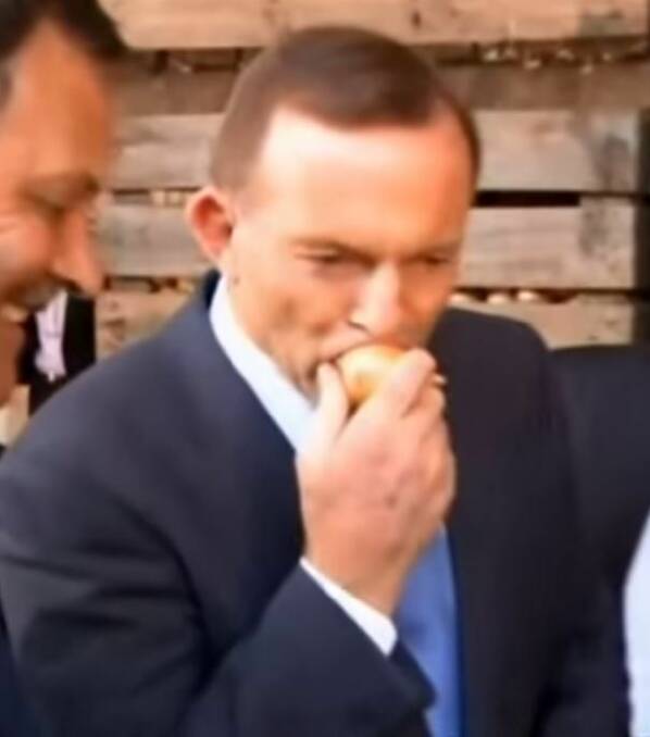 Not so appeeling. Tony Abbott chomps into a raw onion. Photo: supplied