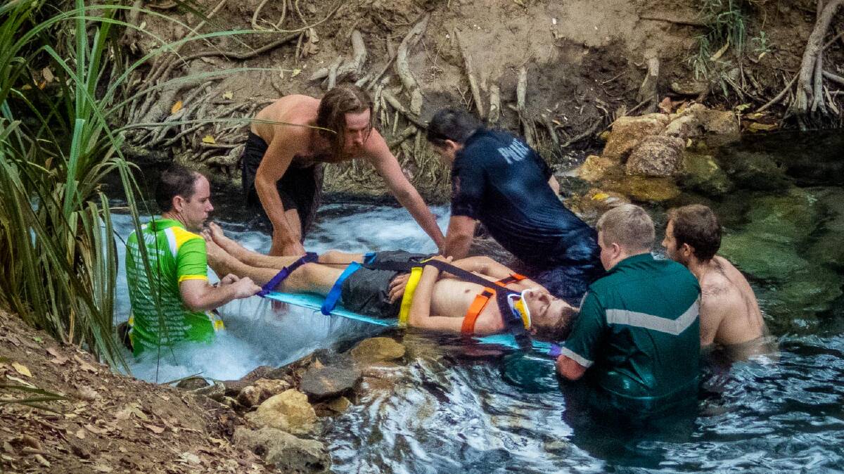 SPRINGS RESCUE: Paramedics and the man's mates help float the badly injured backpacker down the popular Katherine tourist attraction. Picture: Brian Dean.