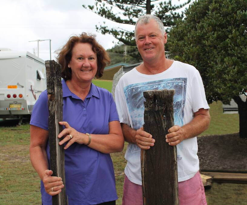 Corinne and Andrew Nelson from Sydney joined locals and tourists in collecting discarded pieces of the old Killick Creek footbridge in Crescent Head as it was dismantled yesterday. Photograph by Kempsey Shire Council.