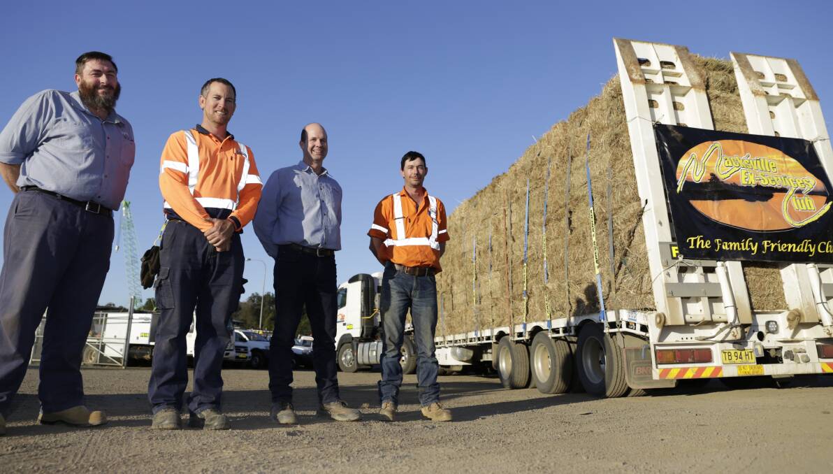 Fortade's Trevor Stride, business owners Brad Fortescue and Wayne Pade, and Ben Donnelly with the semi-load of hay on Friday afternoon