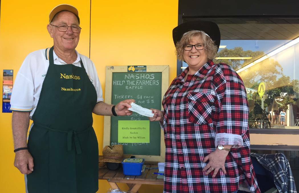 Nasho Neville Stewart hands over $3000 worth of snag sangers to Commbank branch manager Juleanne Bartlett for drought relief, August 17, 2019