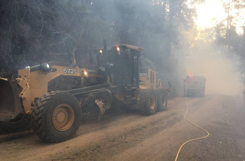 Photo taken by Valla Rural Fire Brigade training officer Chris Knight: "That grader was amazing. 2-3 trees across the road - of decent size - and it smashed them off to the side. Kept our crews safe."