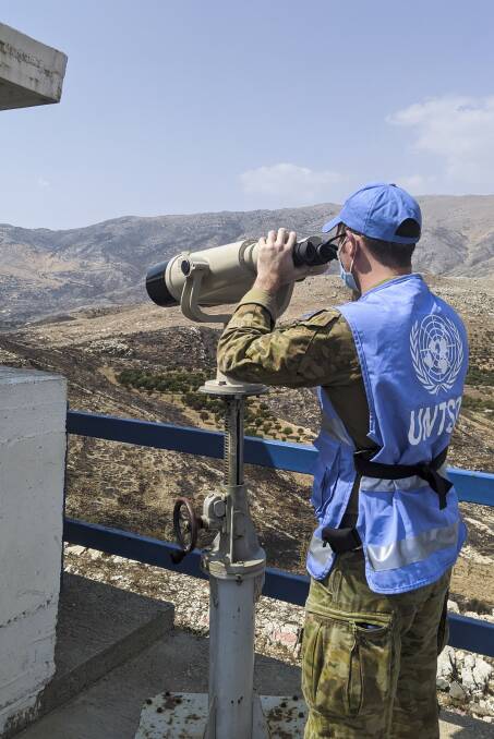 Australian Army officer Captain Zach Lambert scans his sector at Observation Post 73 in Israeli Occupied Golan whilst deployed on Operation Paladin. - Photo Courtesy of the Department of Defence