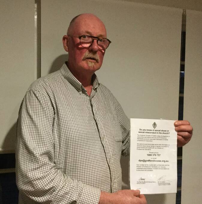 Geoff Richardson holding the poster that failed to mention reporting sexual abuse to the the police 