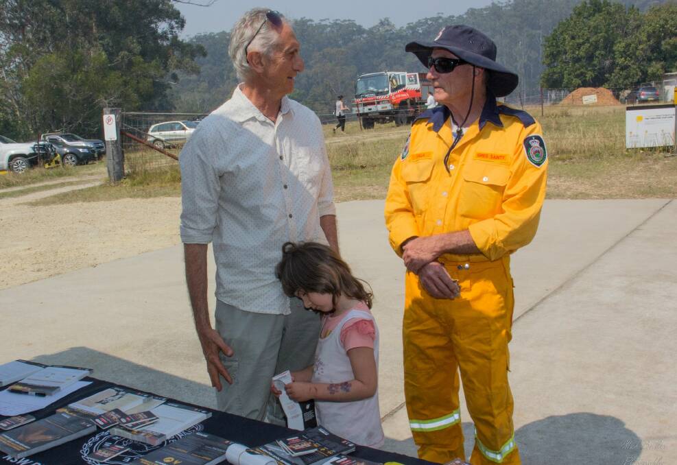 Valla residents Stewart Peters and Ellie Dalceska-Peters advised on bushfire survival from RFS volunteer Greg Sainty. Photo: Mick Birtles