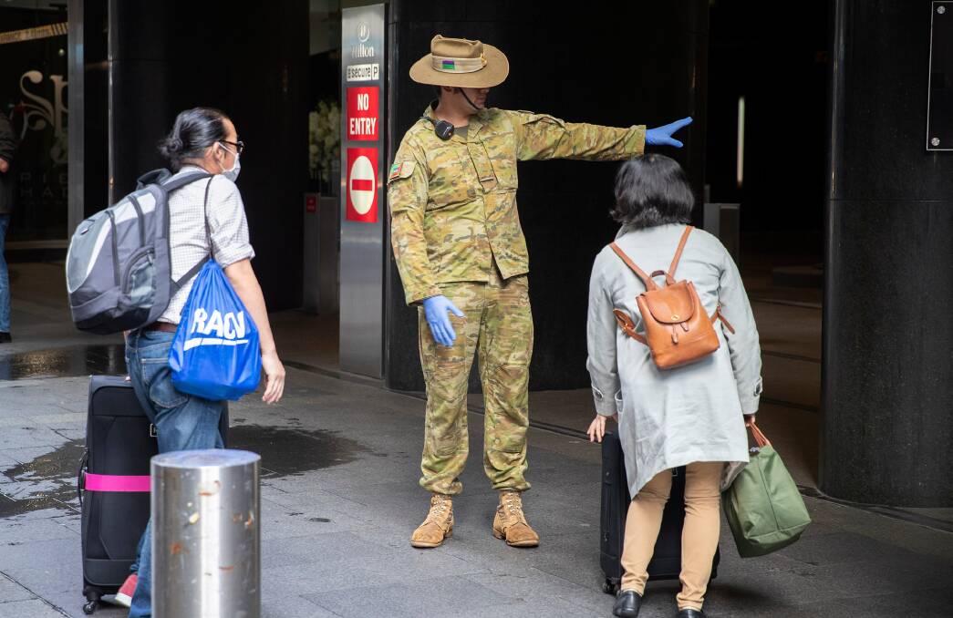 Australian Army soldier Private Claude Allan from 2nd/17th Battalion, Royal New South Wales Regiment, guides returning passengers to their hotel rooms in Sydney, as part of the government's COVID-19 response. Photo: CPL Chris Beerens, Department of Defence
