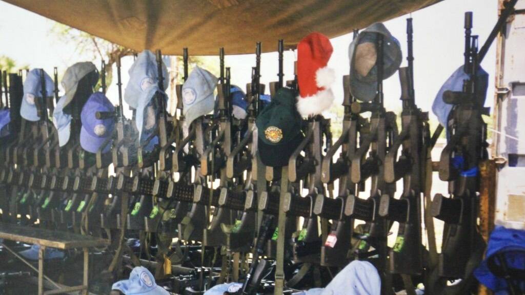Santa leaves his hat in the rifle rack outside the Mess Tent during Christmas lunch at the Australian led, United Nations Forward Operating Base, Batugade, East Timor in 2000. Photo by Mick Birtles.