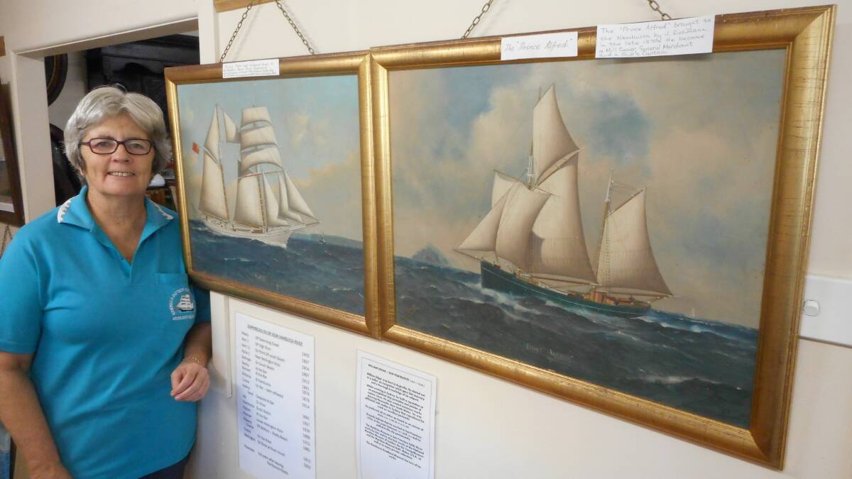 Museum volunteer Rachel Burns with the W Edgar paintings. Photo supplied.
