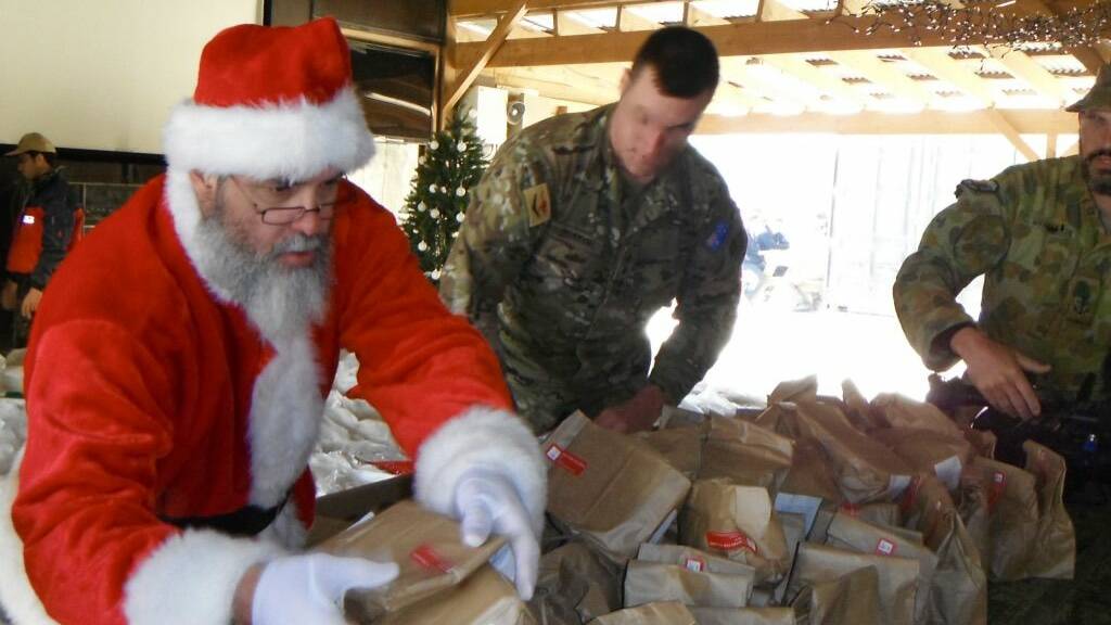 Santa hands out Christmas packages from home to Aussie troops in Tarin Kowt,  Afghanistan, in 2012. Photo by Mick Birtles.