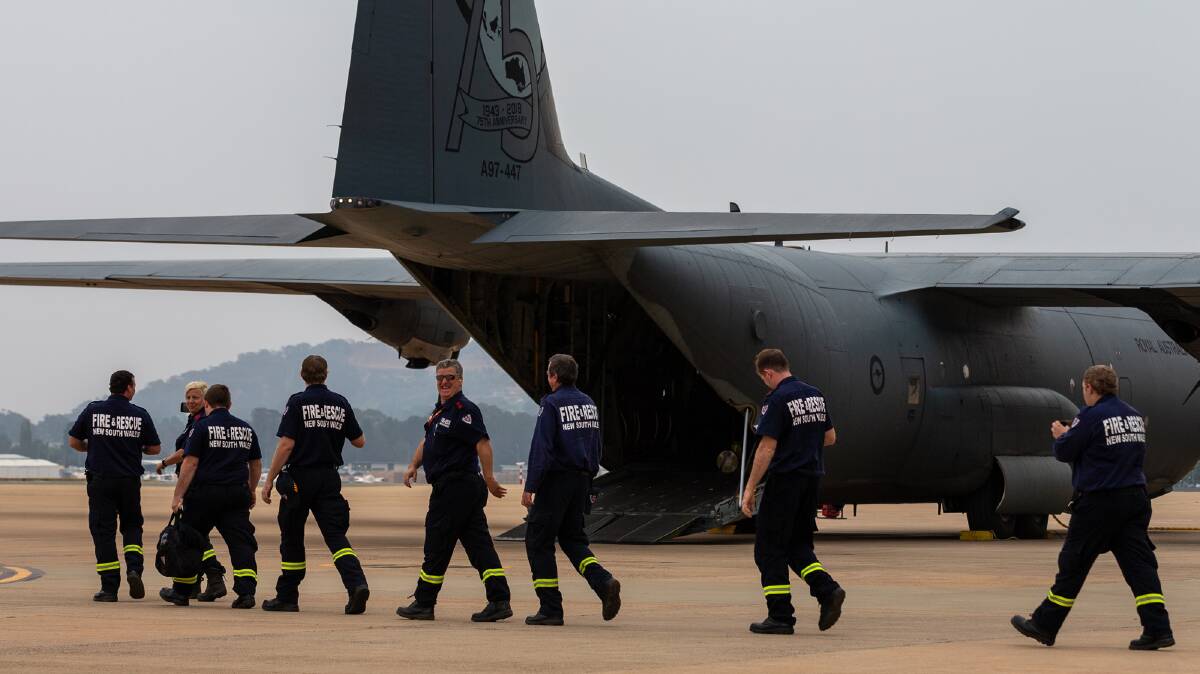 Fire and Rescue New South Wales members board a C-130J Hercules, for their home flight to RAAF Base Williamtown from Defence Establishment Fairbairn, Canberra after fighting fires in Southern NSW since New Years Eve 2019. Photo: PTE Rodrigo Villablanca, ADF