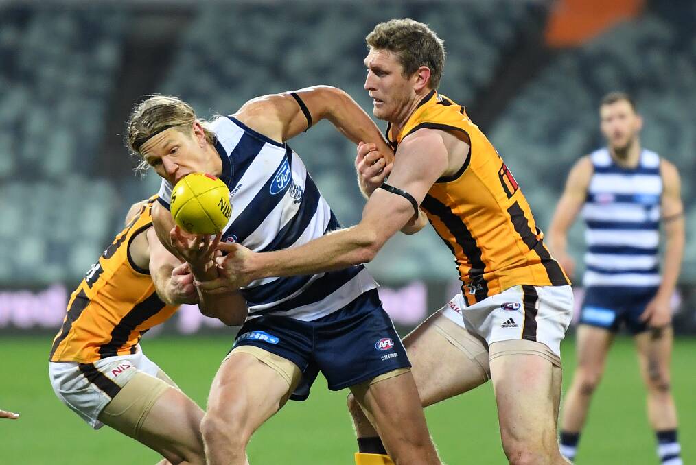 Geelong's Rhys Stanley is tackled by Ben McEvoy of the Hawks during the round 2 AFL match at GMHBA Stadium last Friday night. Stanley had a huge game for the Cats. Photo: Quinn Rooney/Getty Images