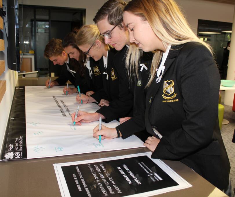 SAY NO: Students from Mackillop College signing the White Ribbon pledge at last year’s Young Leaders event.