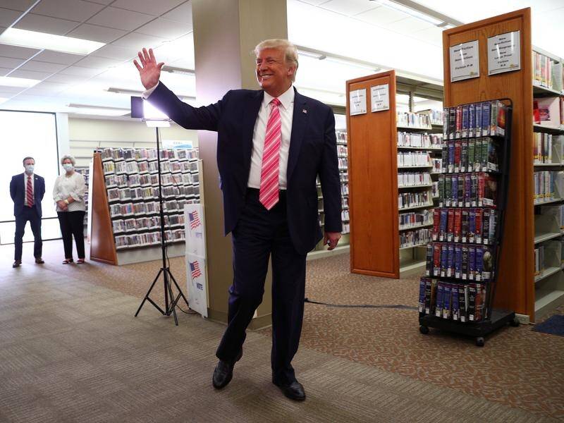 U.S. President Donald Trump waves after casting his ballot at the Palm Beach County Library.
