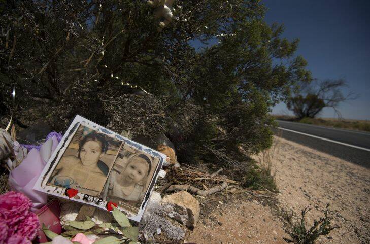 The photos' of Karlie Pearce-Stevenson (left) and her daughter Khandalyce Pearce (right) lay at the roadside memorial of the location of where Khandalyce Pearce's remains were found in a suitcase earlier this year, 2km west of Wynarka, South Australia. 17th November, 2015. Photo: Kate Geraghty