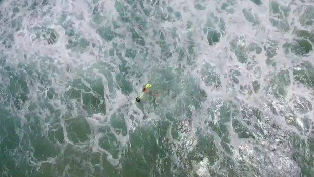 Once they had a grasp on the flotation device, the swimmers were able to make their way to shore.  Photo: NSW GOVERNMENT