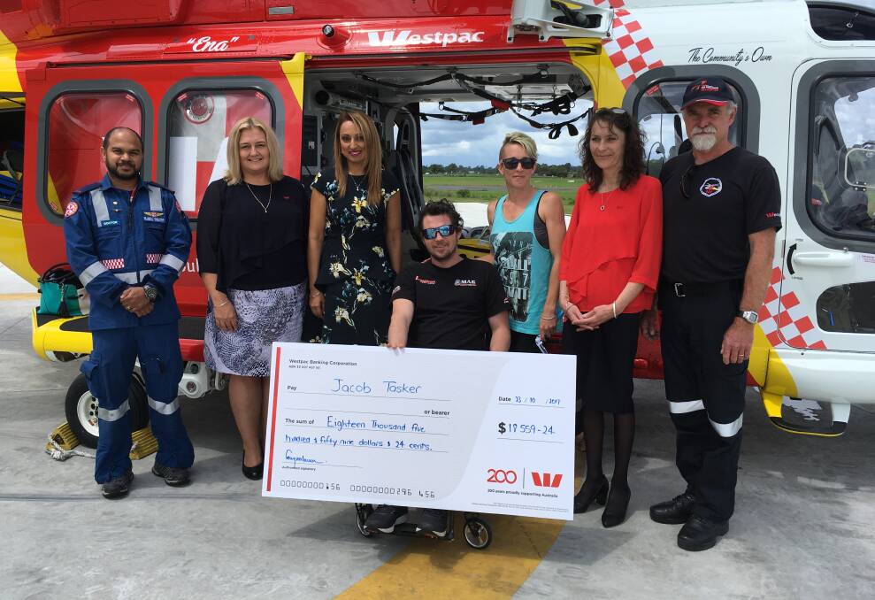 Jake Tasker and his family with members of the Westpac Life Saver Rescue Helicopter and Westpac bank who presented Mr Tasker with their fundraising support.